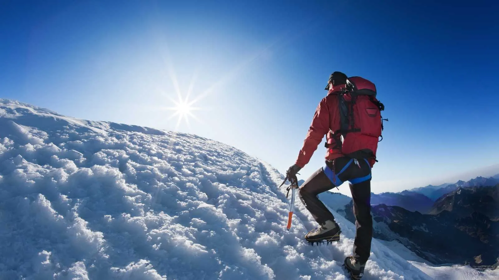 Bergsteiger auf einem verschneiten Grat im Gegenlicht — Sinnbild für den Höhenreiz